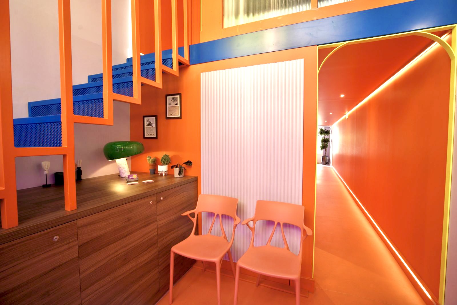 Accueil du cabinet F&eacute;nelon 18 &agrave; Lyon 6 : mur orange, fauteuils et couloir lumineux